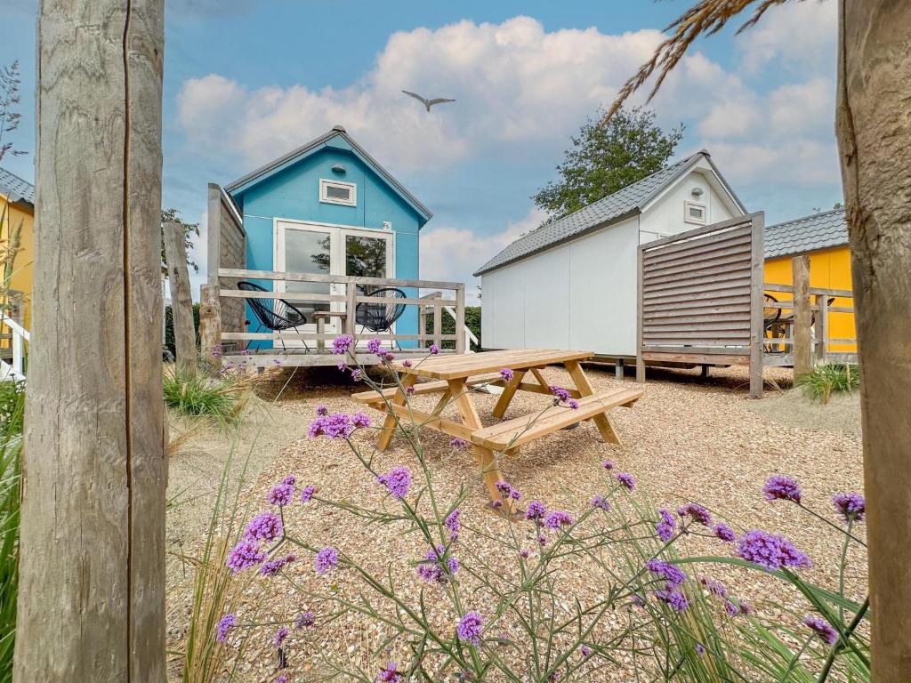 a blue house with a picnic table and a bench at Beach Blue in Ellemeet