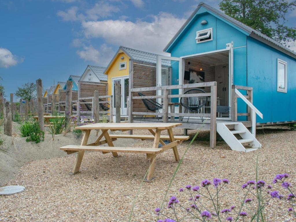 a blue house with a picnic table and a bench at Sea Blue in Ellemeet