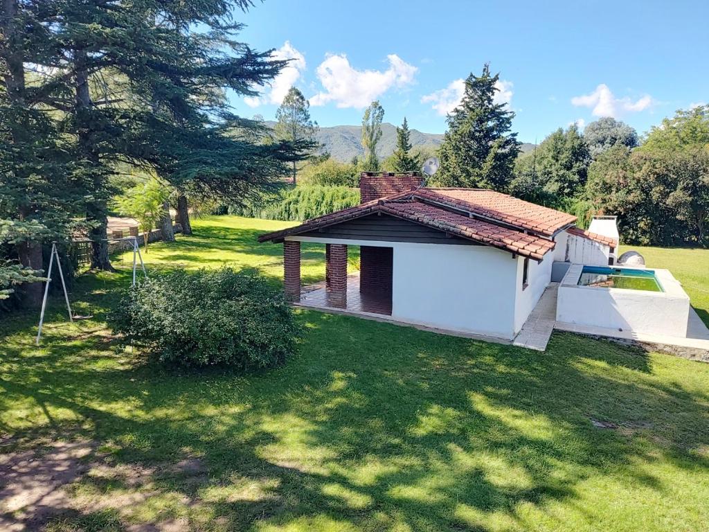 a small white building in a field with trees at Pinos del Virrey I in Valle Hermoso