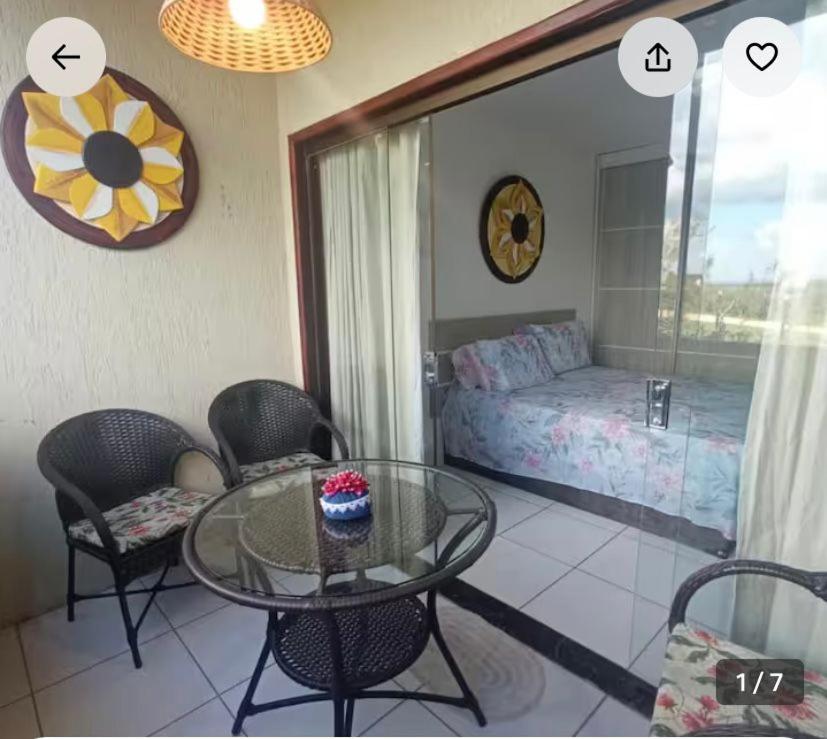 a room with a glass table and chairs and a bed at Monte Castelo Flat in Sairé
