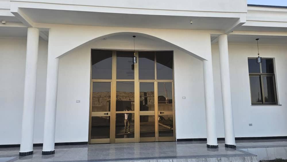 an entrance to a white building with a glass door at Abusera Bishoftu Guest House in Yerer