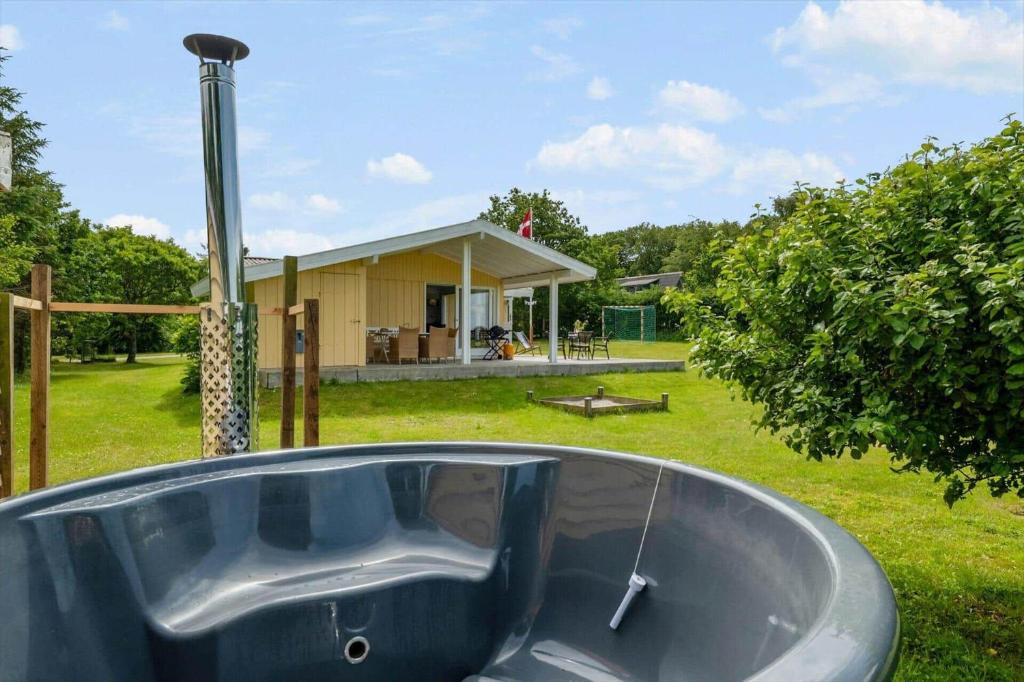 a bath tub sitting in front of a house at LF15083-Farso-Illeris-153 in Hole