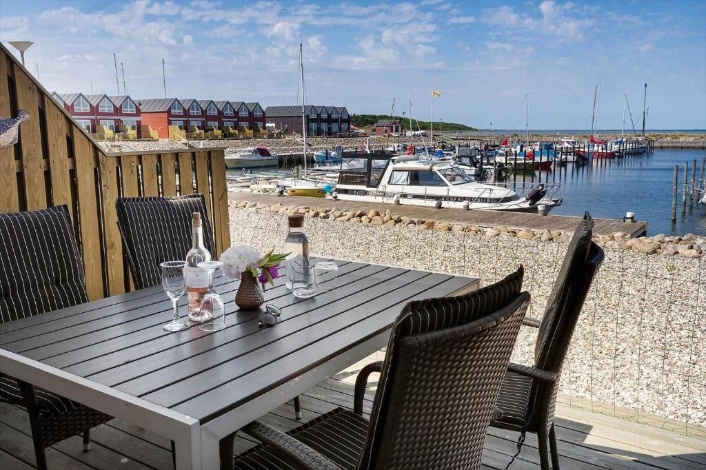 a wooden table with wine bottles and glasses on a patio at 8578-Glesborg-Agterspejlet-13 in Bønnerup Strand