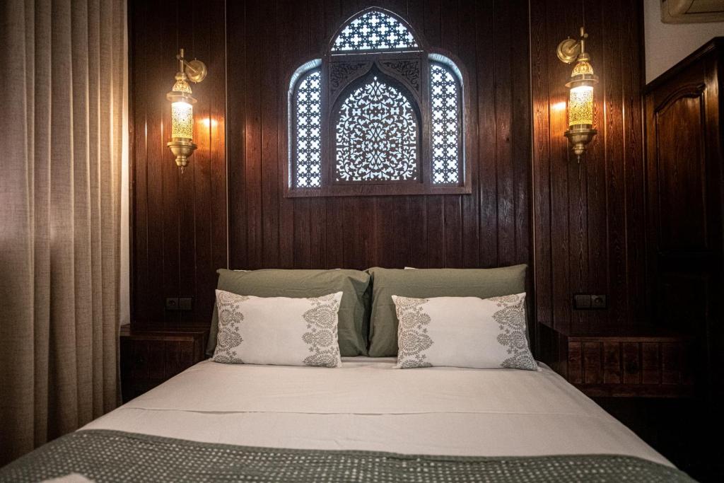 a bedroom with a bed and a window and lights at Casa Bellavista Chaouen in Chefchaouen