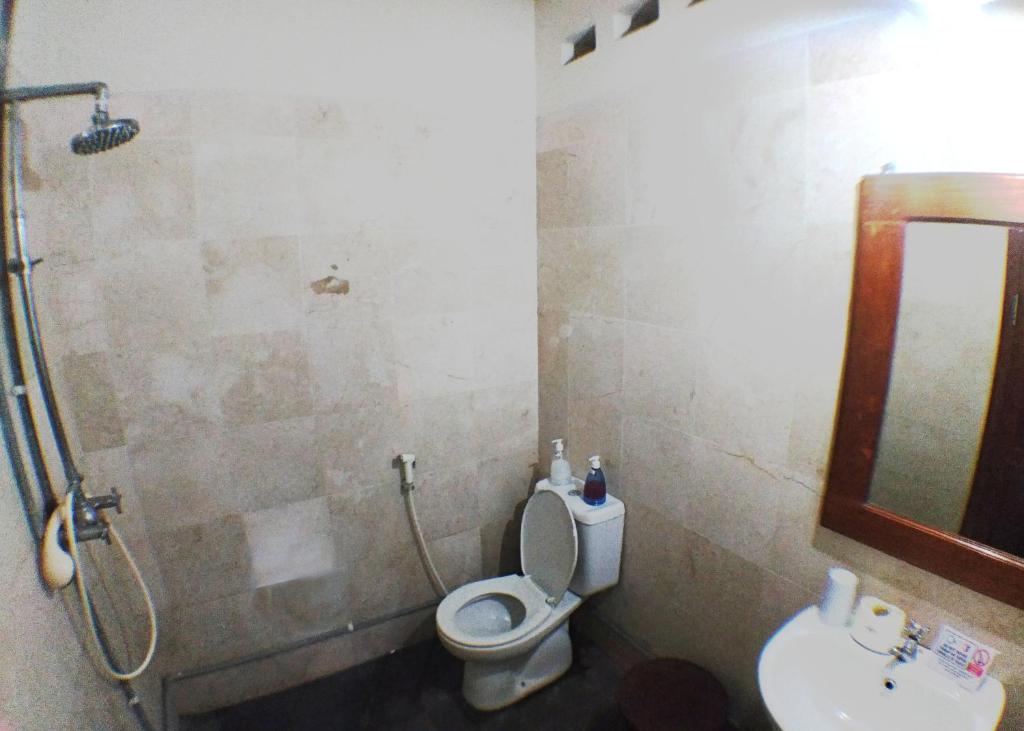 a bathroom with a shower and a toilet and a sink at Omah Pitoe Yogya Homestay in Yogyakarta