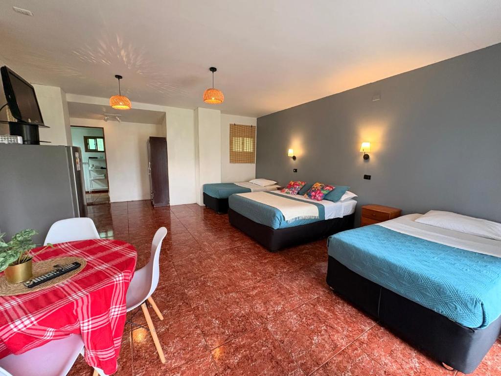 a hotel room with two beds and a table at Cabañas Honu Nui Inn in Hanga Roa