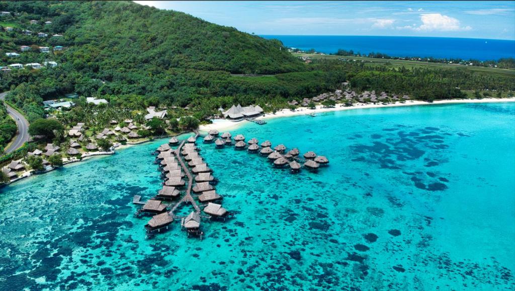 an aerial view of a beach with umbrellas in the water at Sofitel Kia Ora Moorea Beach Resort in Maharepa