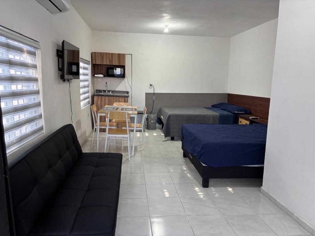 a room with two beds and a couch and a table at Depas Expo Estadio in Monterrey