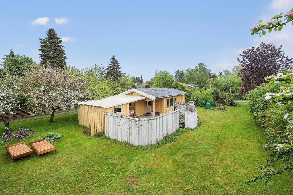 a small house in a yard with a fence at SL365-Rude-Vejrovej-1 in Bisserup Strand