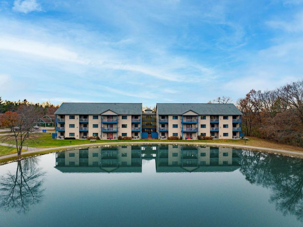 an apartment building with a pond in front of it at Club Wyndham Tamarack in Wisconsin Dells
