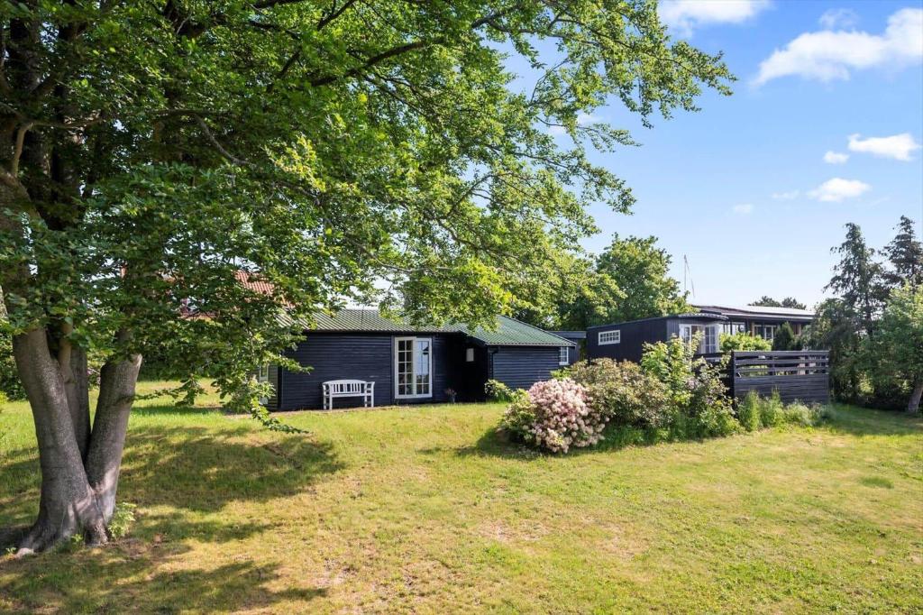 a house in a yard with a tree at SL369-Rude-Hvirvilsvej-4 in Bisserup