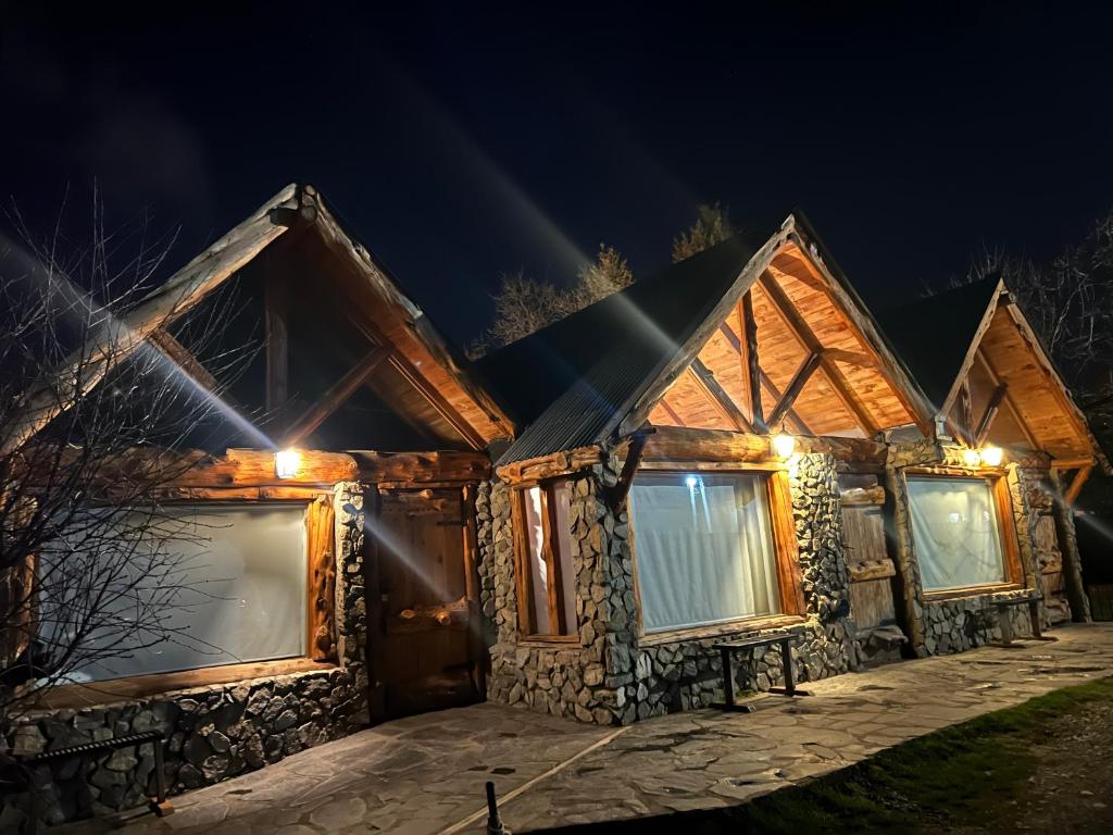 a log cabin with lights on it at night at Bolson deptos in El Bolsón