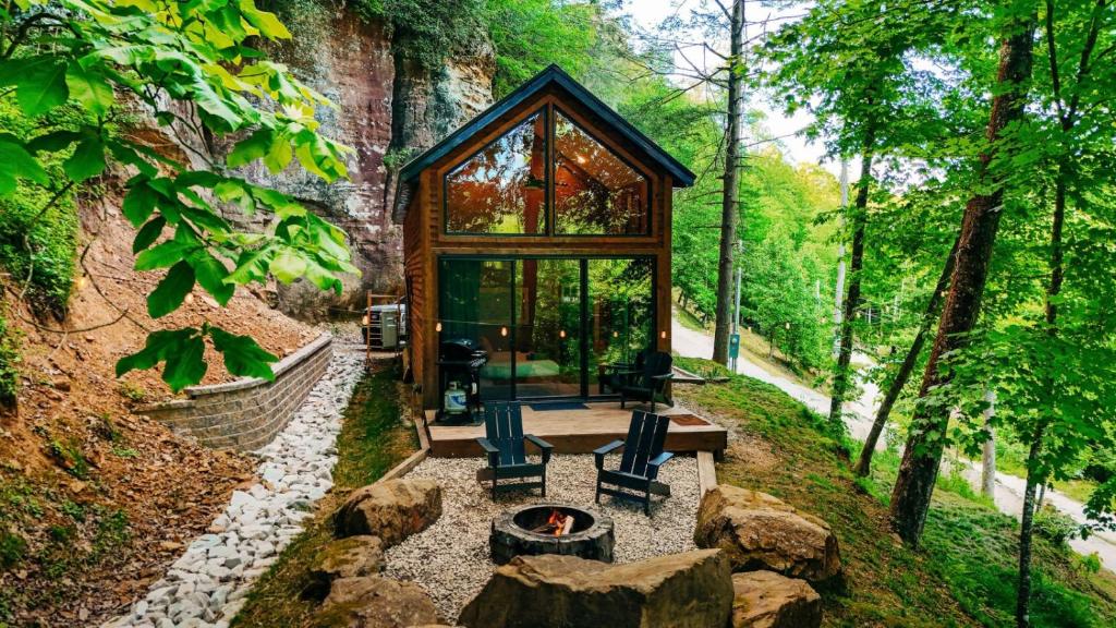 a glass house in the middle of a forest at The Taoist 5min to Gorge with Private Cliffs in Rogers