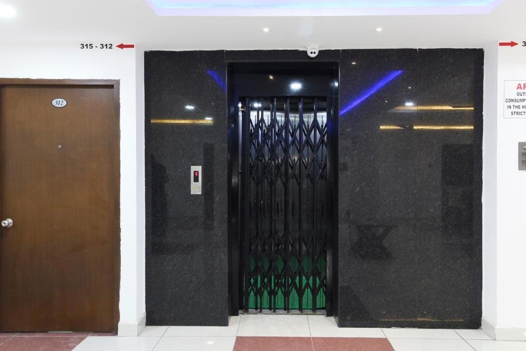 a door in a building with green glass at Collection O Mythri Hotel Near By ECIL, AS RAO Nagar, Sainikpuri in Hyderabad