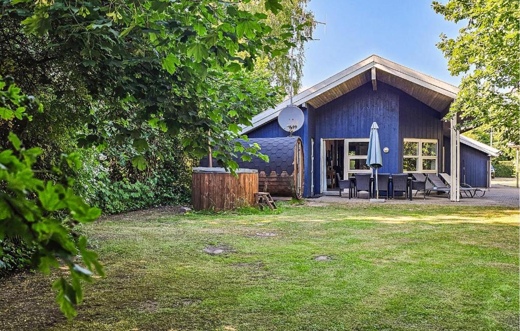a blue house with a table in front of it at Pet Friendly Home In Oksbøl With Sauna in Oksbøl