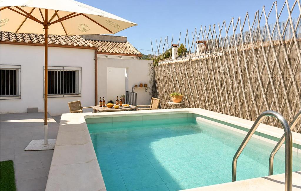 a swimming pool with an umbrella next to a house at Lovely Home In Abarán in Abarán