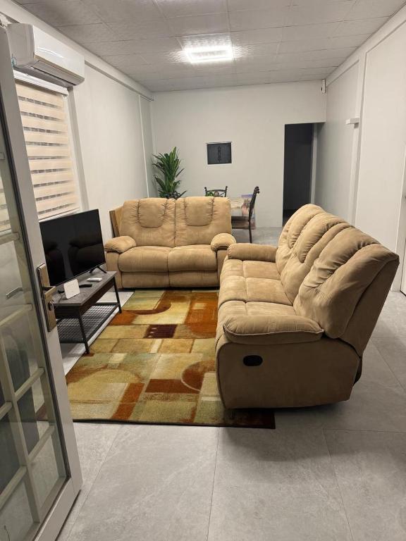 a living room with a couch and a table at Golden Isles Paradise in Port-of-Spain