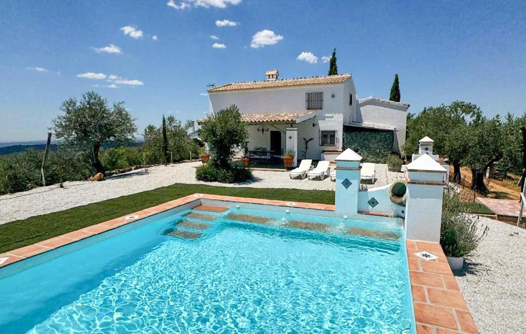 a villa with a swimming pool in front of a house at 4 Bedroom Awesome Home In Constantina in Constantina