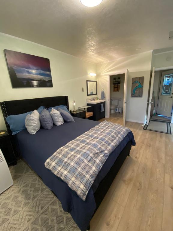 a bedroom with a large bed with a blue bedspread at Lake Room in Sandpoint