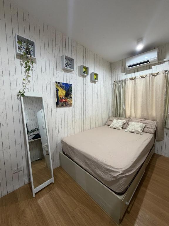 a small bedroom with a bed and a mirror at DASIG Homes1 near airport, Bayanihan Flats 1 Condominium Mactan in Pajak