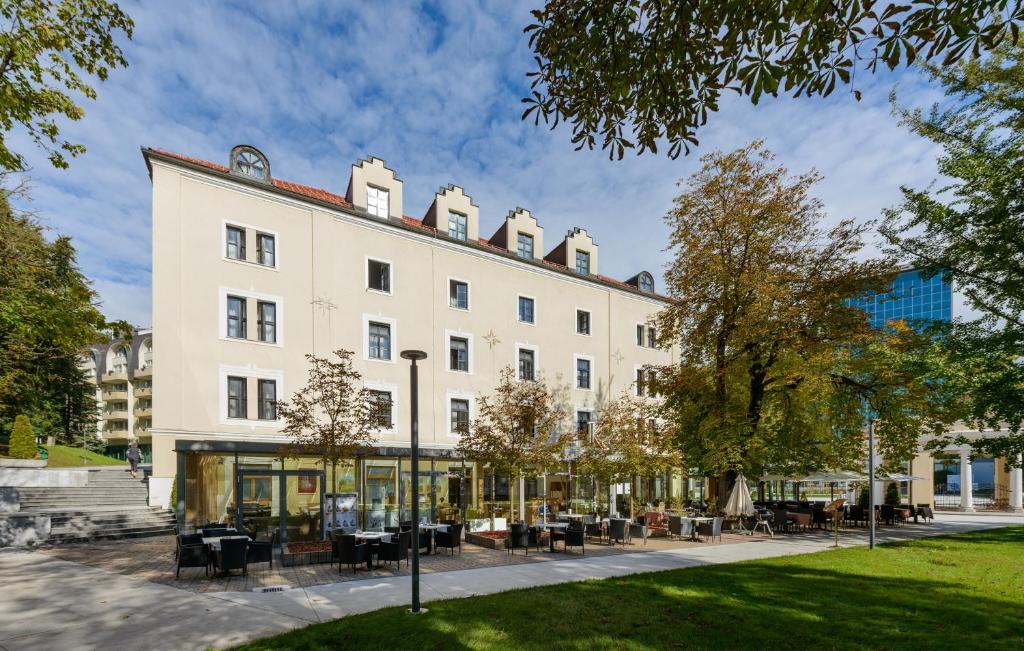 a large white building with tables and chairs at Hotel Zagreb - Health & Beauty in Rogaška Slatina