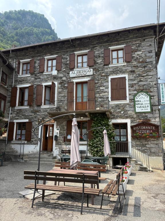 a building with benches and umbrellas in front of it at Nonaj in Rima San Giuseppe