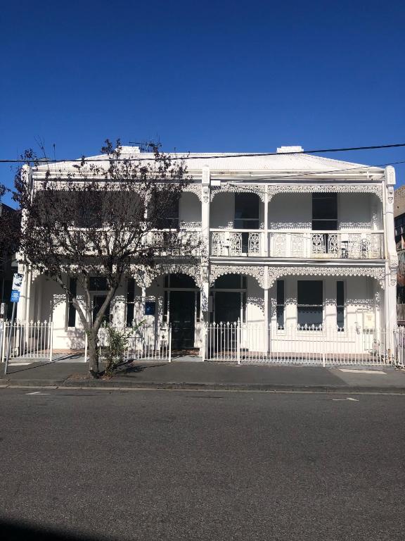 a white building with a fence in front of it at Windsor Green Hotel in Melbourne