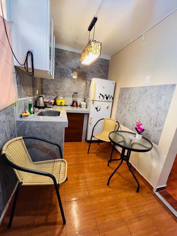 a kitchen with a table and two chairs and a table at Hospedaje el Trujillanito in Víctor Larco Herrera