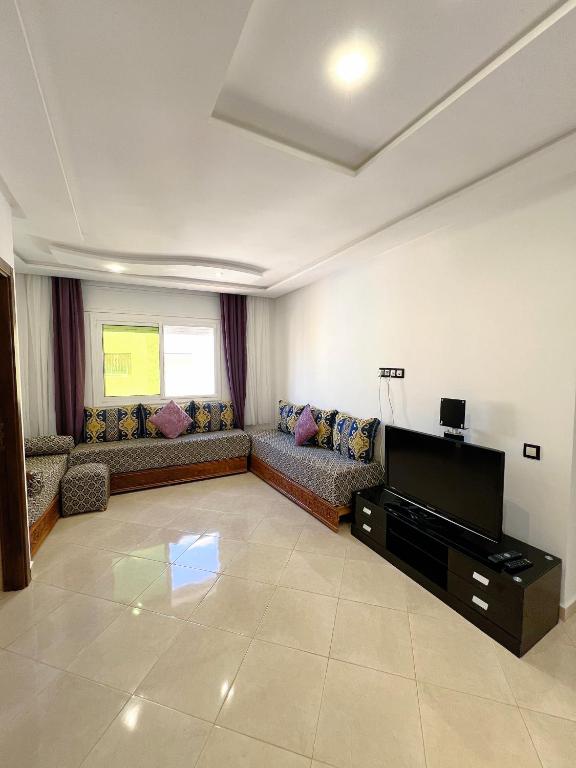 a living room with a couch and a flat screen tv at Visit Chamal - Palmera 3 in Oued Laou