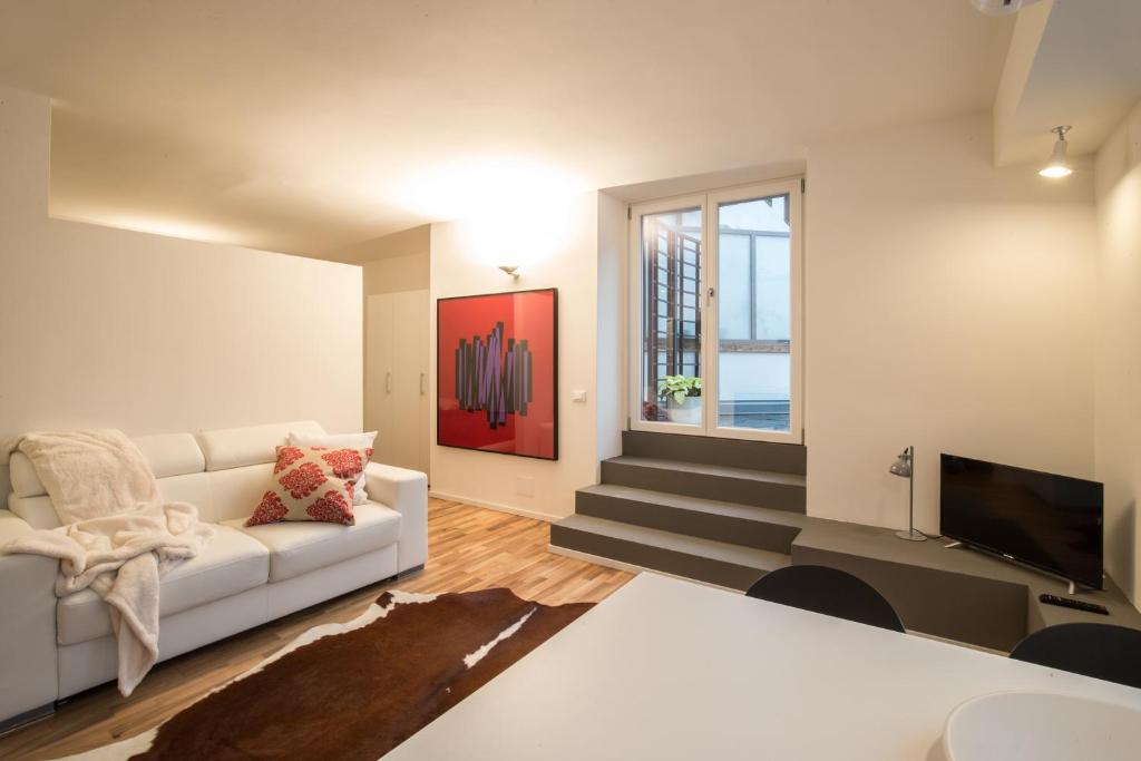 sala de estar con sofá blanco y TV en Casa Marchiodi en Trento