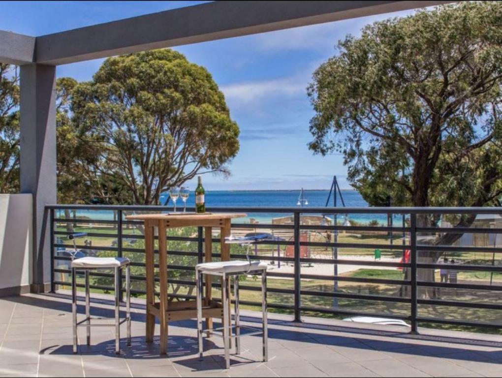a table and chairs on a balcony with a view of the ocean at Seaside Escape Rockingham in Rockingham