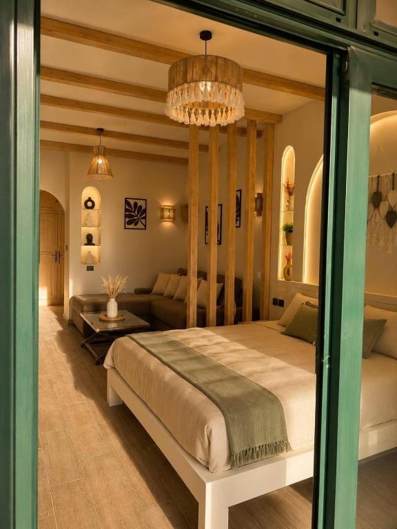 a bedroom with a large bed and a couch at La Hacienda Ras Sedr in Ras Matarma