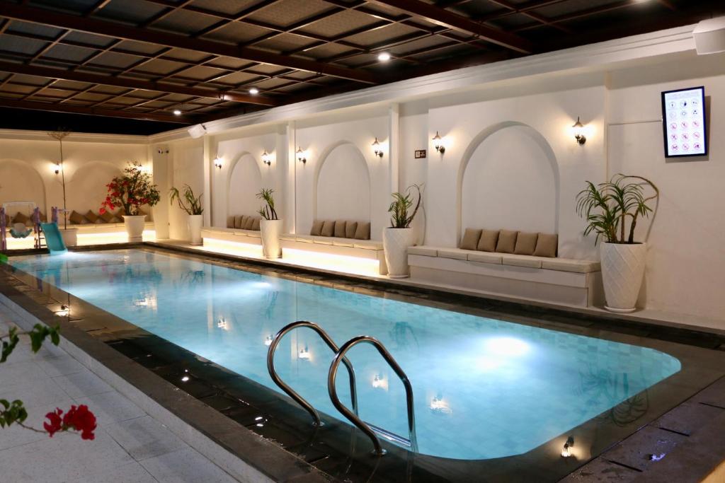 a large swimming pool in a building with a pool at Hotel Roditha Banjarbaru in Banjarbaru