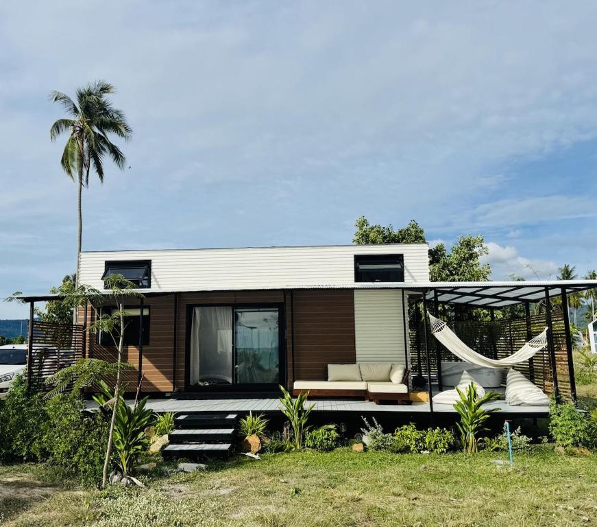 a tiny house with a hammock in the yard at Private Sunset Beachfront Thainee Villa in Nathon Bay