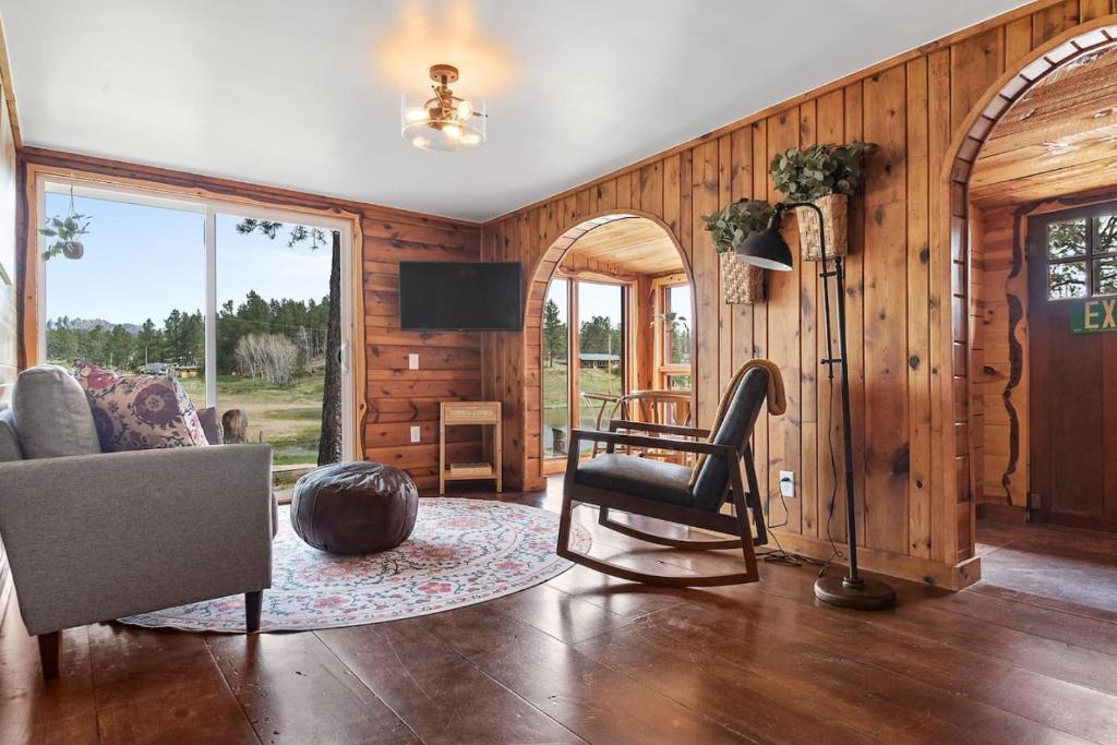 a living room with a couch and a chair and a television at Hobbit Hole BHBungalows #3 in Custer