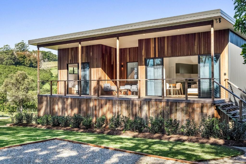 a house with large glass doors and a balcony at Fernleigh Stay in Fernleigh