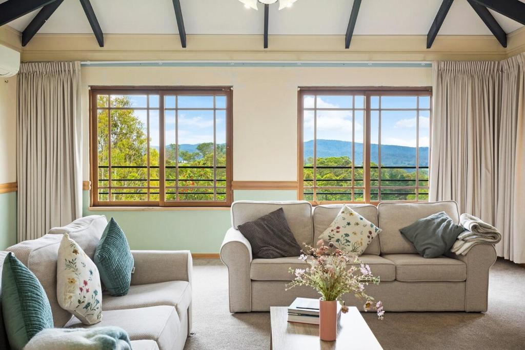 a living room with a couch and windows at Twilight Ridge in Bega
