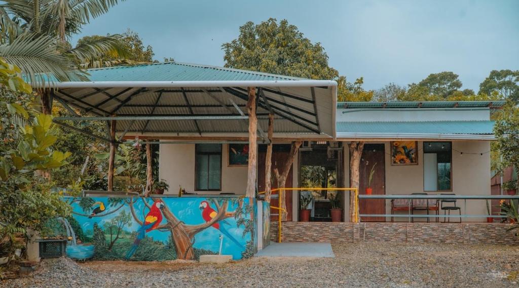 a house with a painting on the side of it at Cabinas Los Colibris in Pocosol