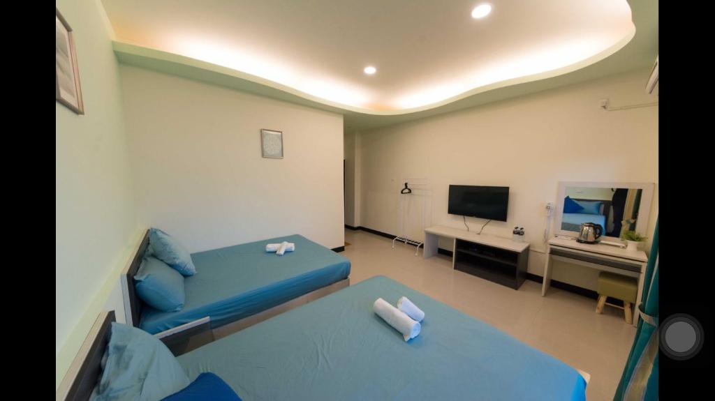 a small room with a blue bed and a desk at Kenting Orange Homestay in Hengchun