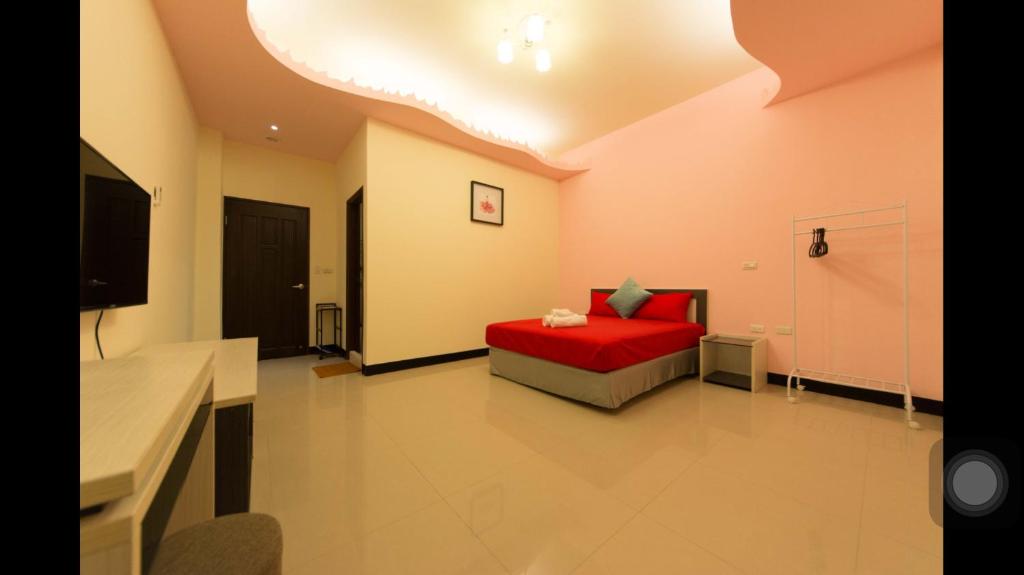 a bedroom with a red bed in a room at Kenting Orange Homestay in Hengchun