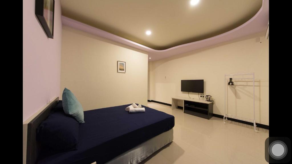 a bedroom with a blue bed and a television at Kenting Orange Homestay in Hengchun