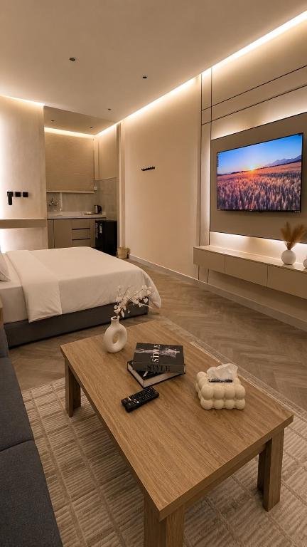 a bedroom with a bed and a table with a tv at Luxury Smart Entry Studio in Buraydah