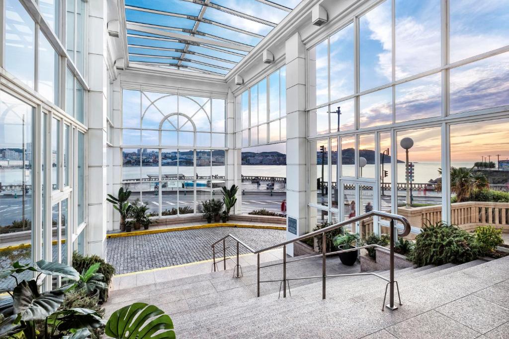 a large building with large windows and plants at Meliá Maria Pita in A Coruña