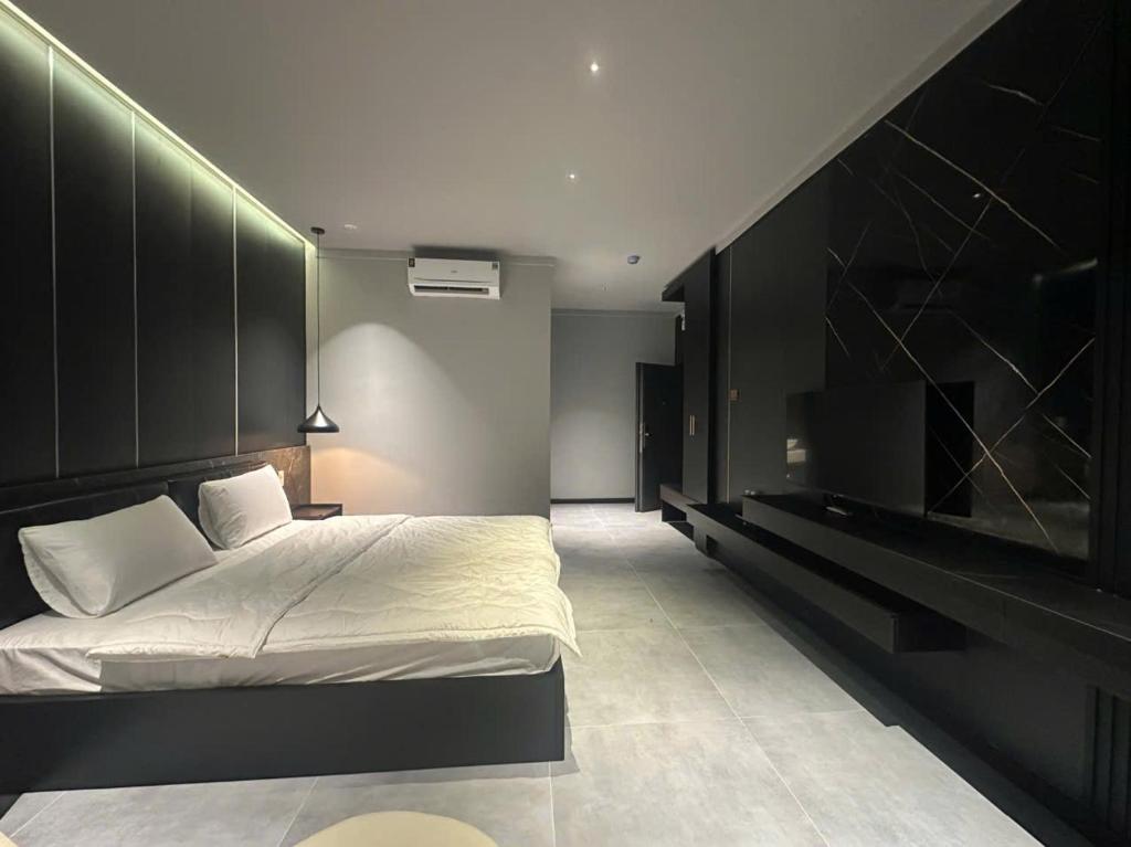 a bedroom with a large bed and a television at Mia Hotel in Ga Trảng Bôm