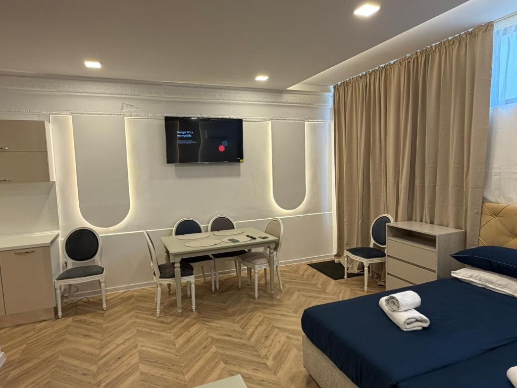 a hotel room with a bed and a table and a tv at Tempo apartments in Pazardzhik