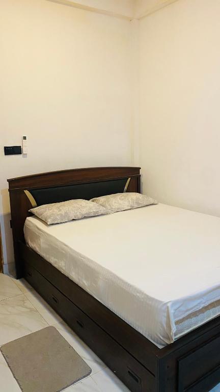 a bed in a room with a wooden bed frame at Calm bay in Minneriya