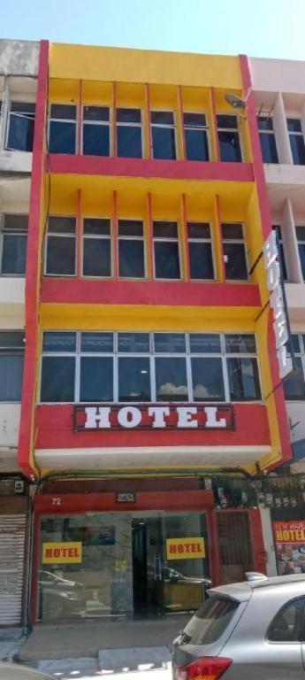 a yellow and red building with a sign on it at Georgetown New Wave Hotel in George Town