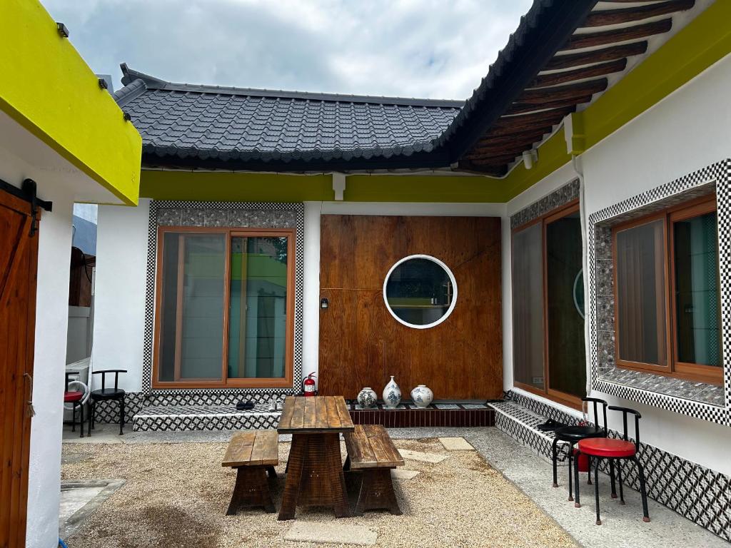 a patio with benches and a table on a house at Hanok Stay Ohneul in Gyeongju