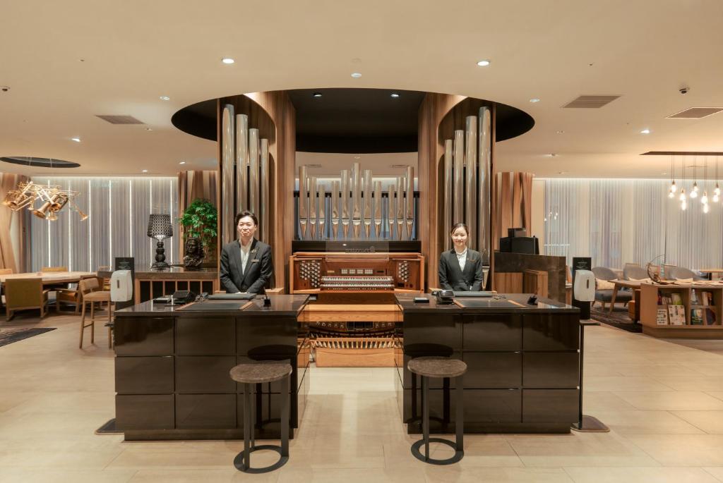 two men sitting at a desk in a lobby at Hotel GrandBach Sendai in Sendai