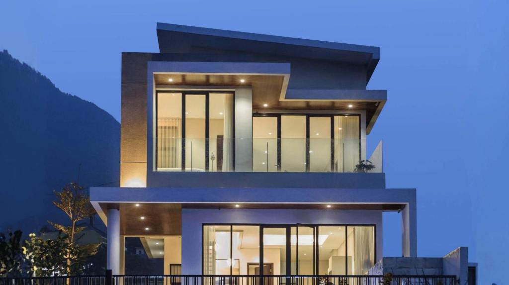 a house with a blue facade at night at Alcola Boutique Villa - Astonia Unit in Batu